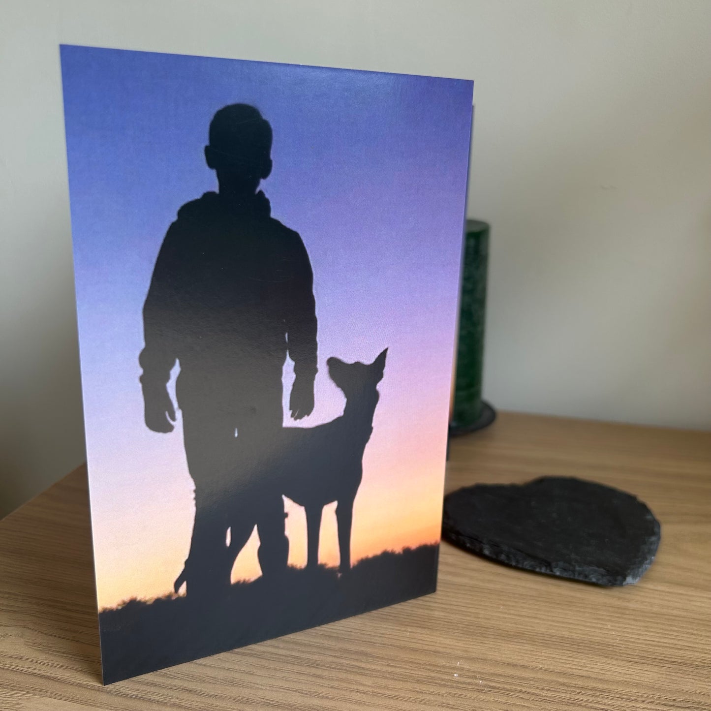The image shows a photo of the front of the Bare Cards Dog Photo Sentiment Card 'I've got you' showing a silhouette of a boy with his dog looking up at him on a sunset background.