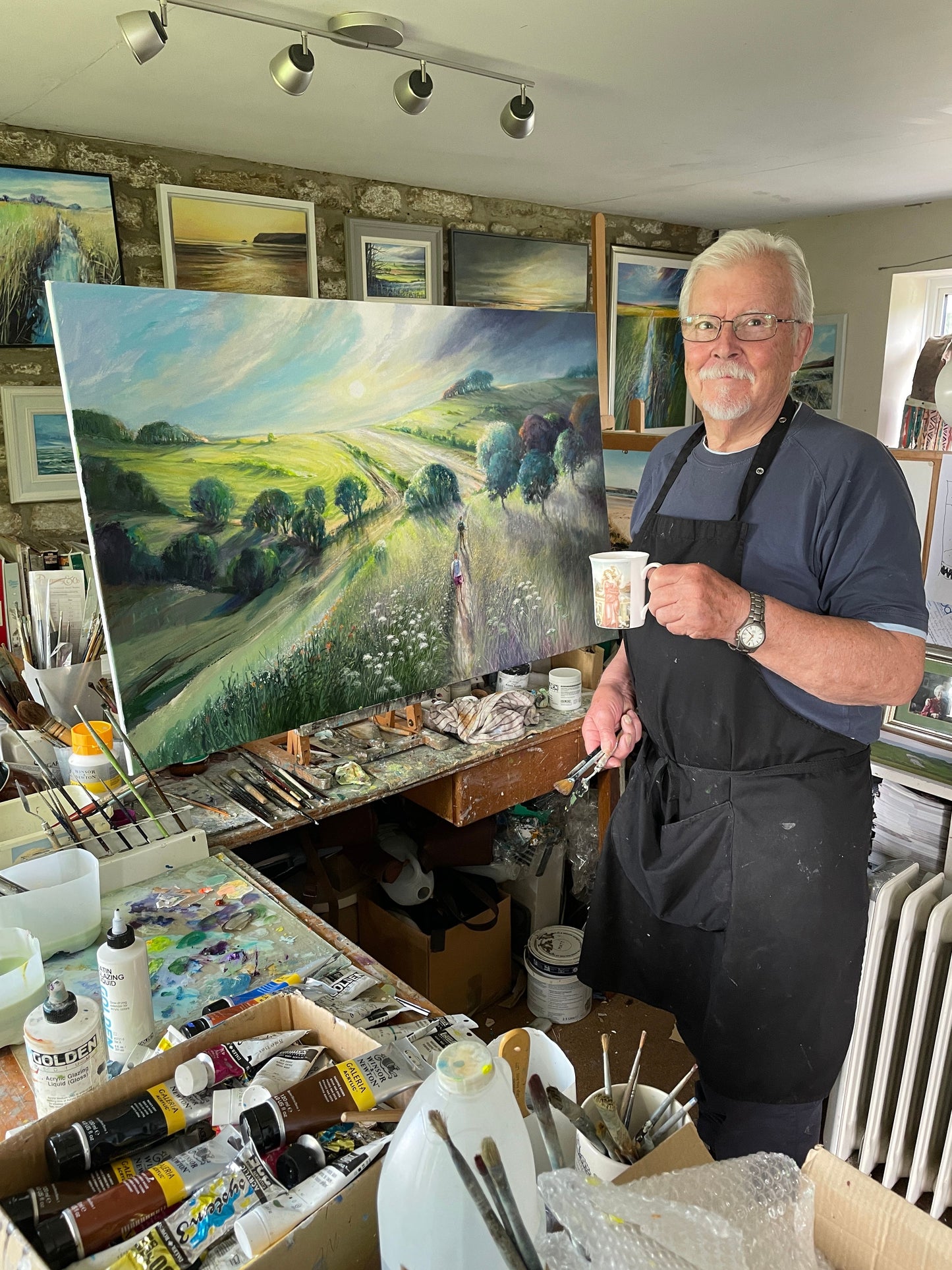 A photo of John L Harris, the artist behind the Bare Cards collection, pictured in his studio painting