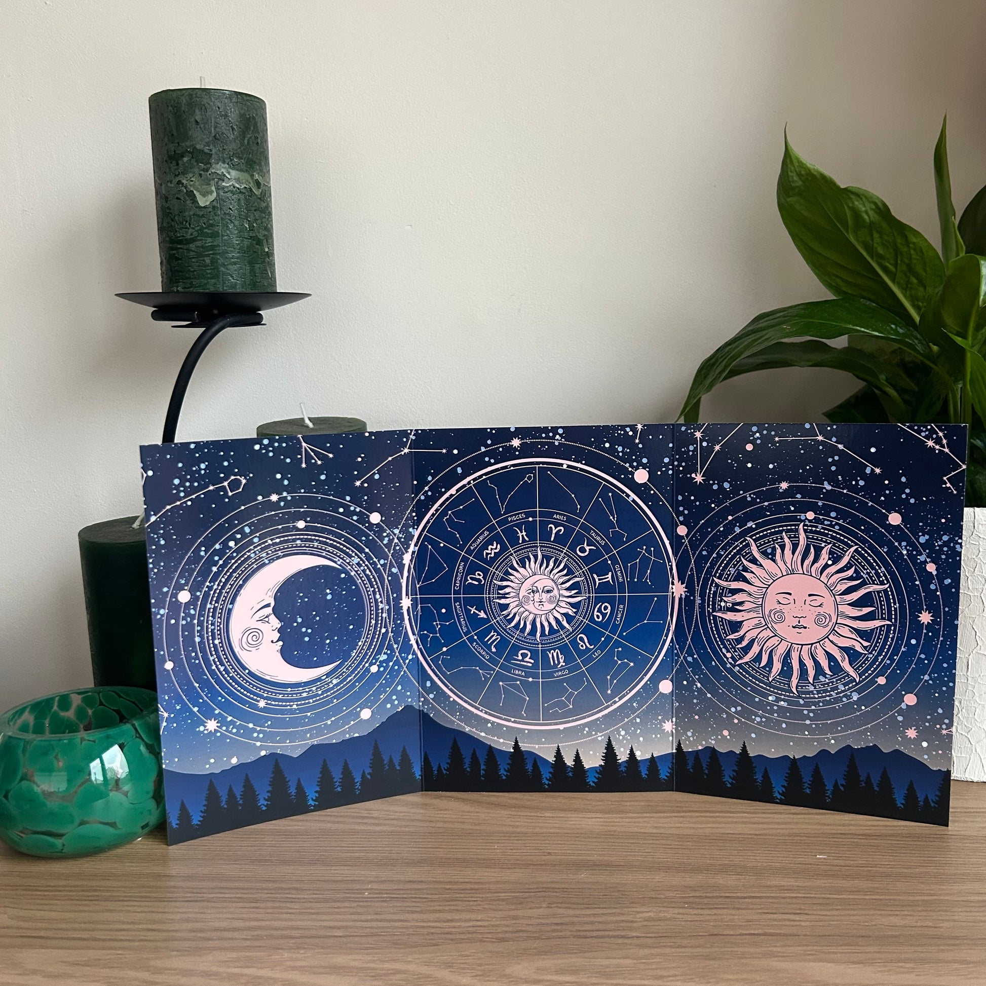 Decorative card with celestial designs featuring sun, moon, and star patterns on a wooden surface.