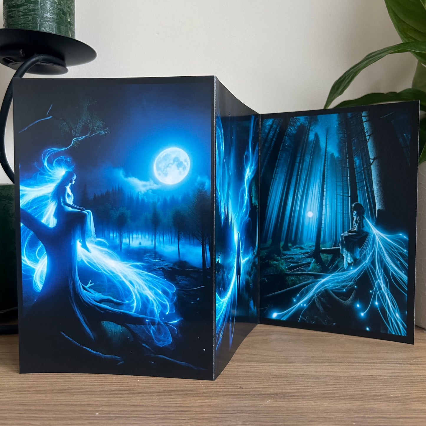 Glowing blue fairy in a forest with a full moon, displayed on a stand.