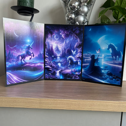 Three fantasy-themed posters featuring unicorns on a wooden surface.
