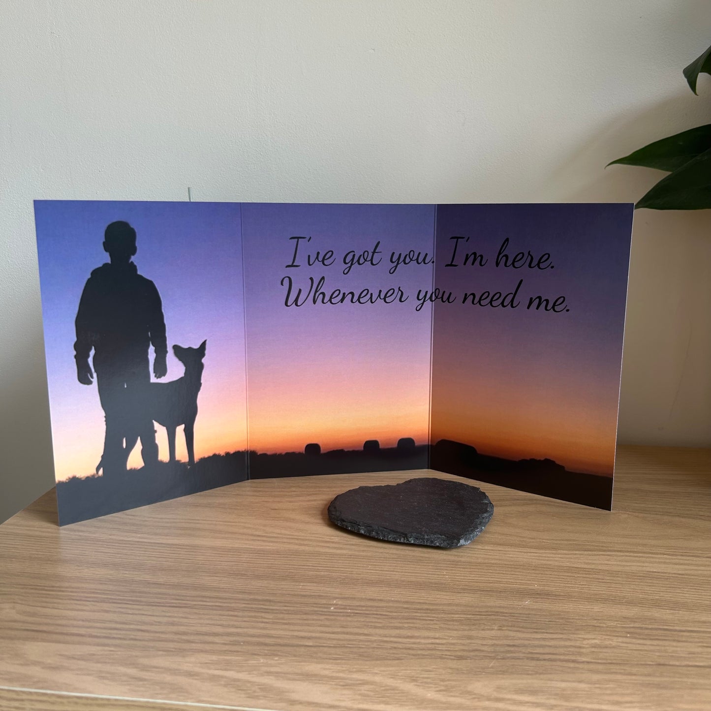 The image depicts a photo of the Bare Cards Dog Photo Sentiment Card 'I've got you' with the full trifold image open showing a silhouette of a boy with his dog looking up at him on a sunset background. The caption on the card reads 'I've got you. I'm here. Whenever you need me.'