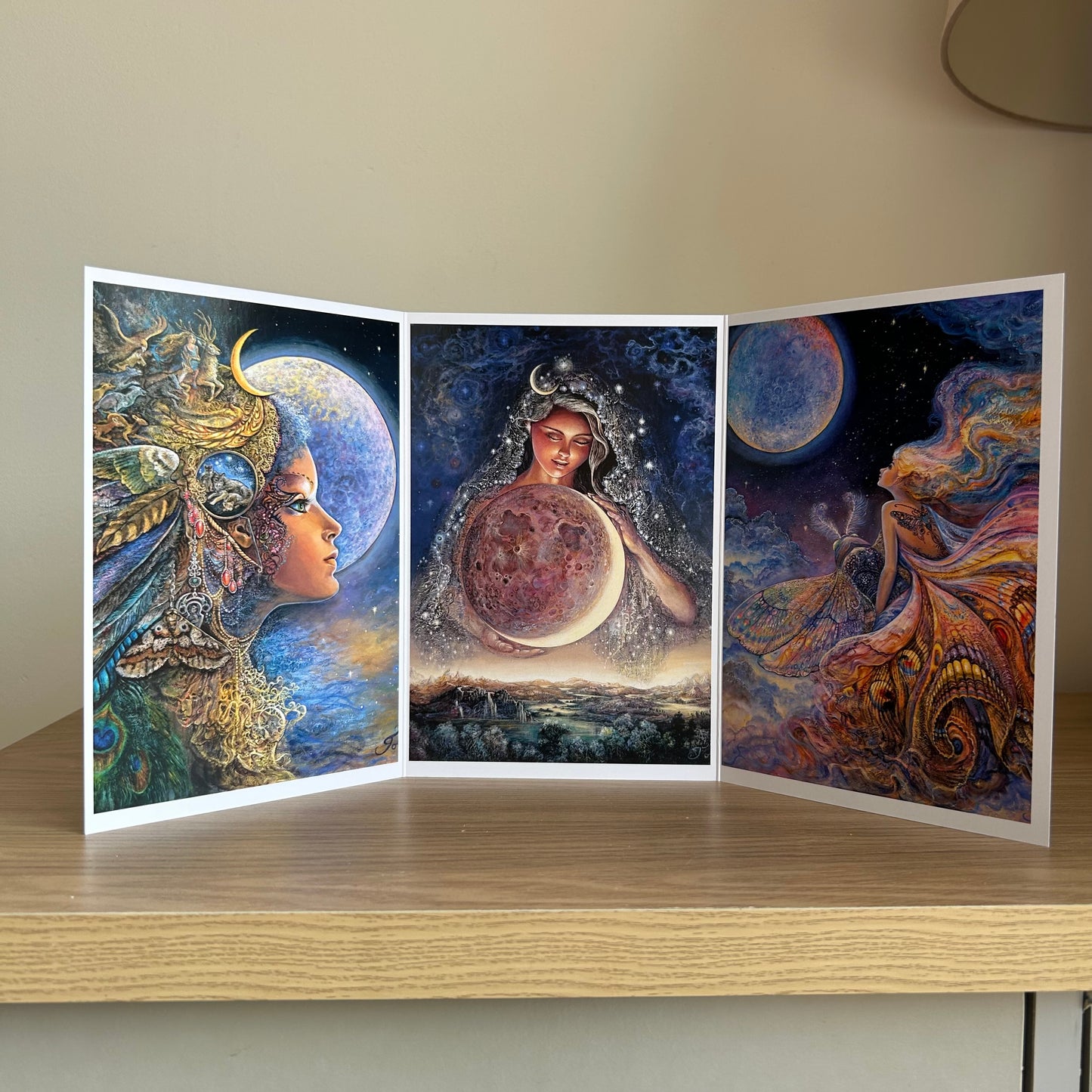 Three-panel self-sealing greetings card UK with artistic fantasy designs featuring Josephine Wall paintings of the moon goddess Diana and mystical moon paintings on a wooden surface