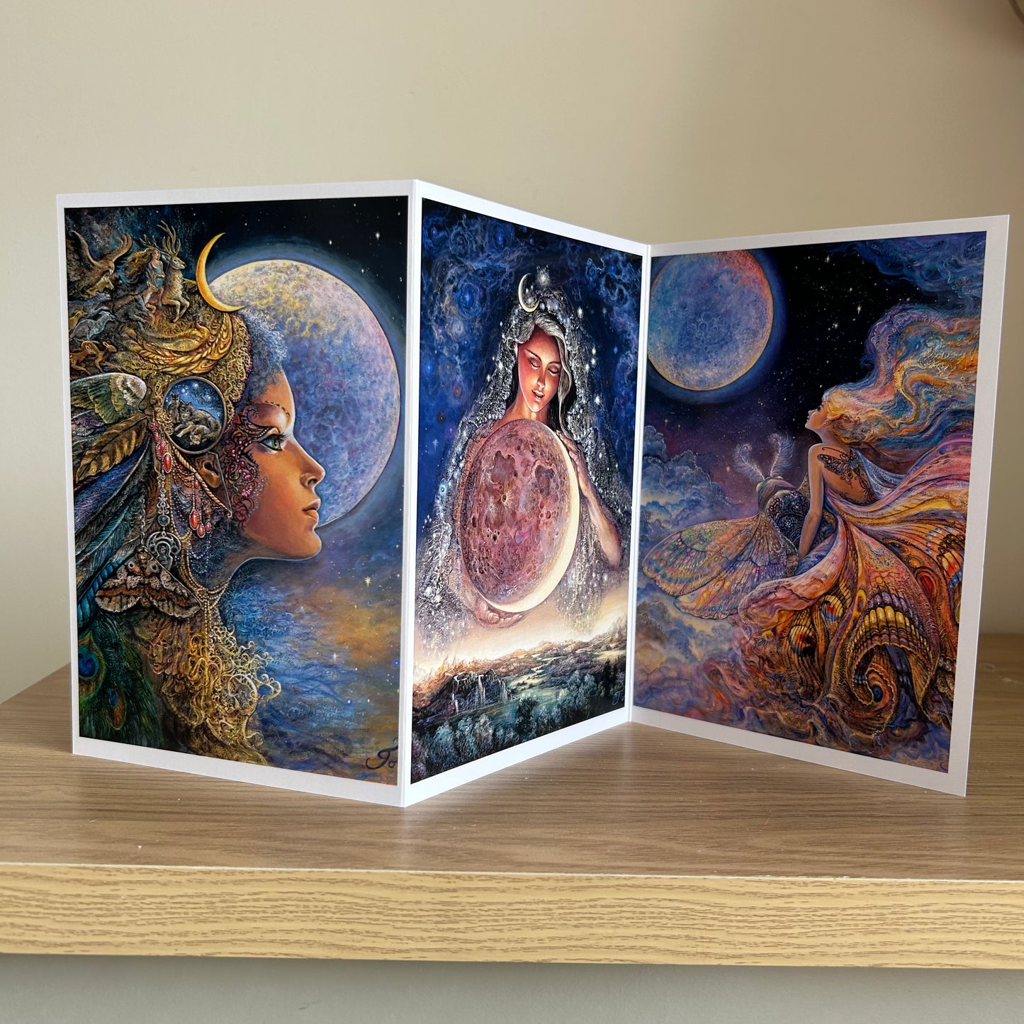 Three-panel self-sealing greetings card UK with artistic fantasy designs featuring Josephine Wall paintings of the moon goddess Diana and mystical moon paintings on a wooden surface