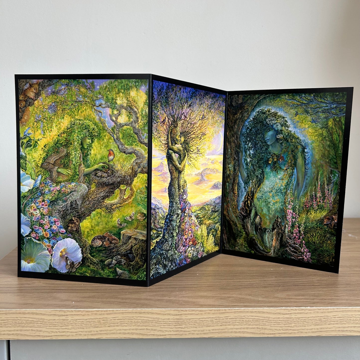 Three-panel self-sealing greetings card with artistic depiction of nature and figures on a wooden surface.
