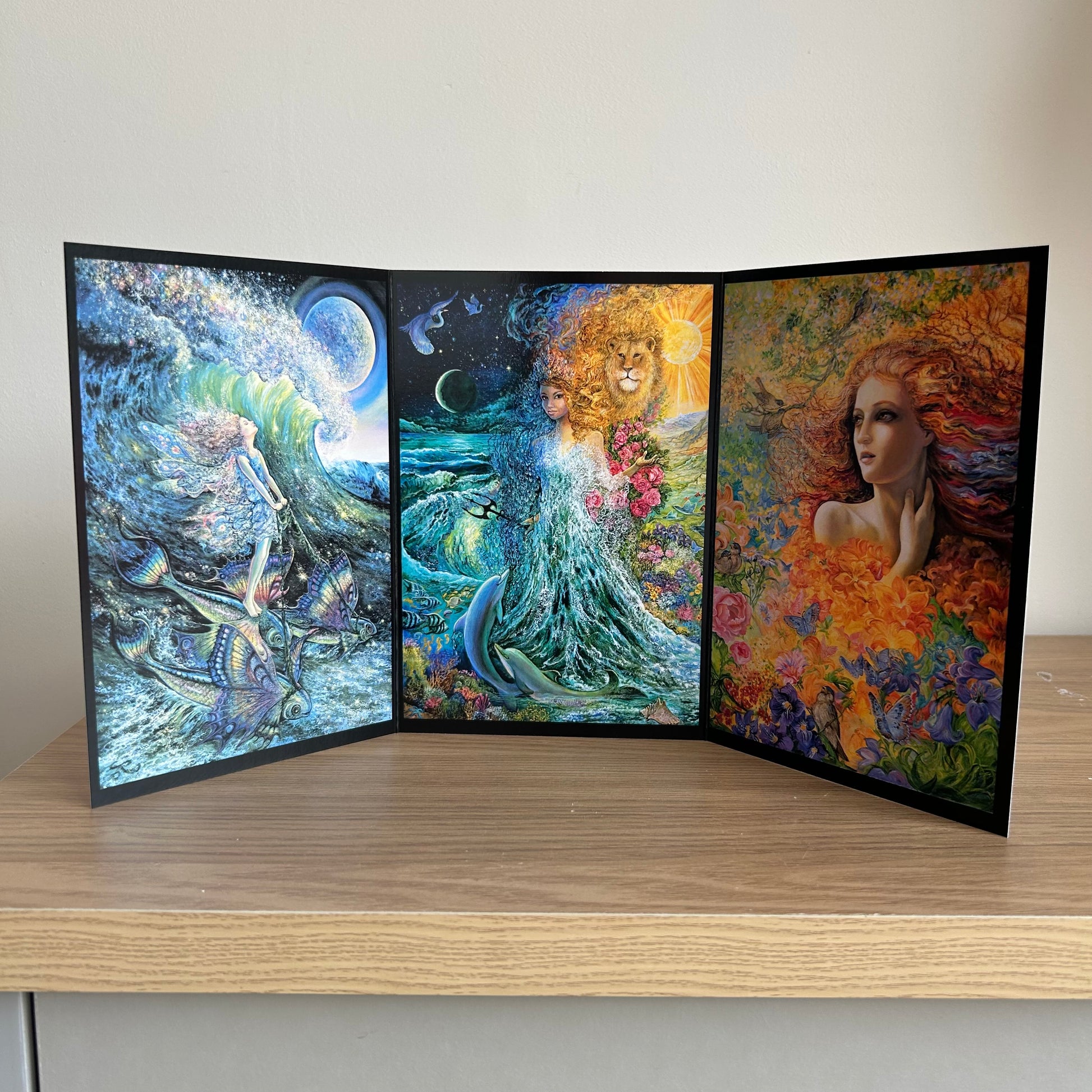 Three-panel self-sealing greetings card UK with artistic fantasy designs featuring Josephine Wall paintings of mystical figures on a wooden surface