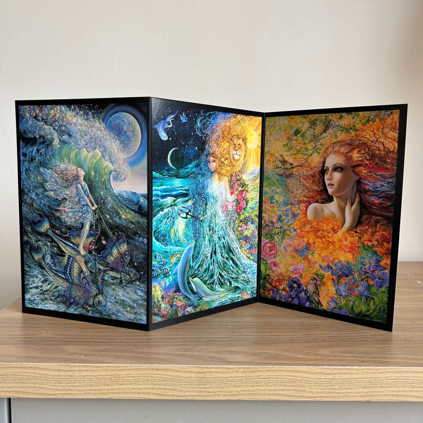 Three-panel self-sealing greetings card UK with artistic fantasy designs featuring Josephine Wall paintings of mystical figures on a wooden surface