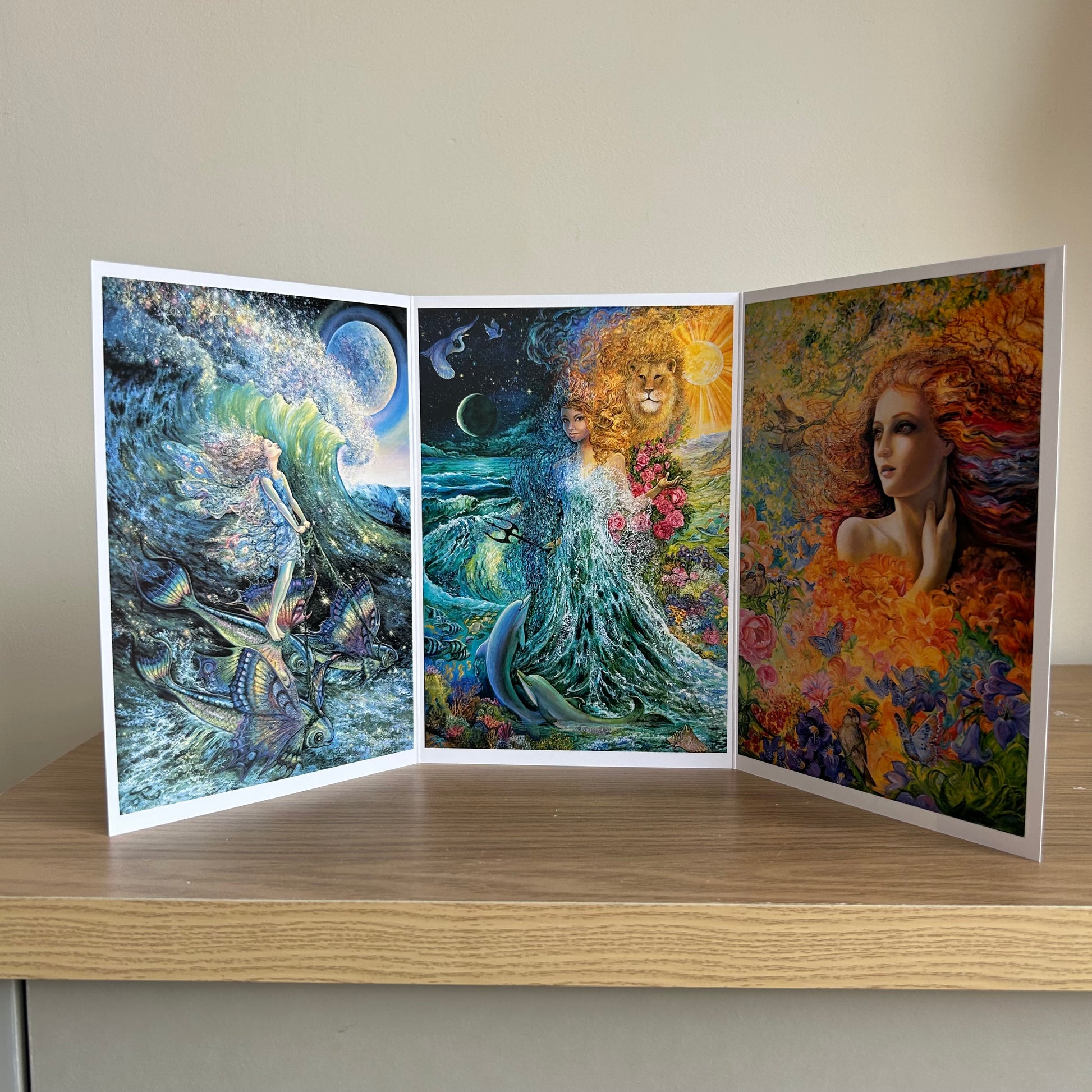 Three-panel self-sealing greetings card UK with artistic fantasy designs featuring Josephine Wall paintings of mystical figures on a wooden surface