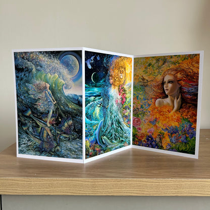 Three-panel self-sealing greetings card UK with artistic fantasy designs featuring Josephine Wall paintings of mystical figures on a wooden surface