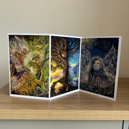Three-panel self-sealing greetings card UK with artistic fantasy designs featuring Josephine Wall paintings of nature, fairies and mystical figures on a wooden surface