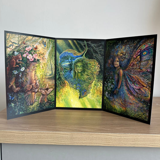 Three-panel self-sealing greetings card UK with artistic fantasy designs featuring Josephine Wall paintings of nature, fairies and mystical figures on a wooden surface
