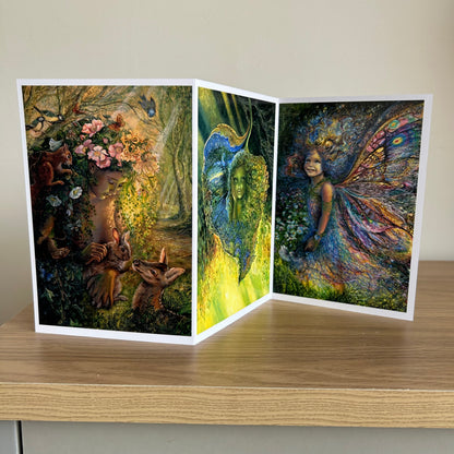 Three-panel self-sealing greetings card UK with artistic fantasy designs featuring Josephine Wall paintings of nature, fairies and mystical figures on a wooden surface