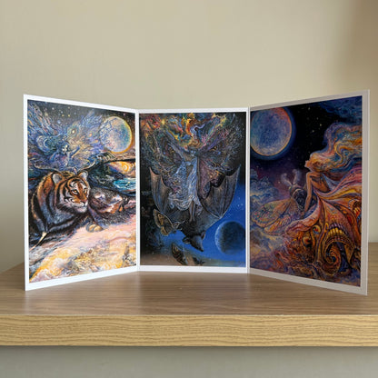 Three-panel self-sealing greetings card UK with artistic designs of fairy figures riding animals to the moon on a wooden surface.
