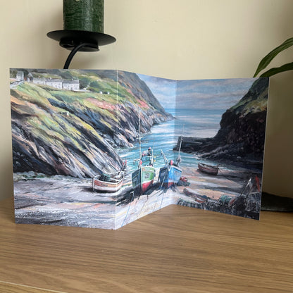 Trifold greetings card with a scenic view of boats in a harbor on a wooden surface.