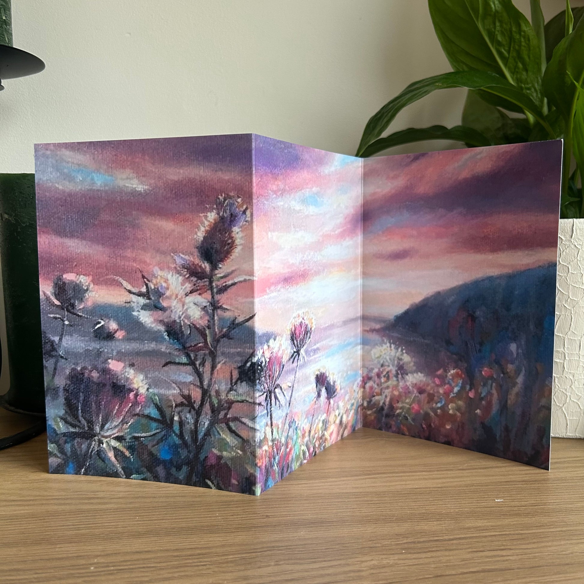 Folded card with an Atlantic Sunset painting on a wooden surface