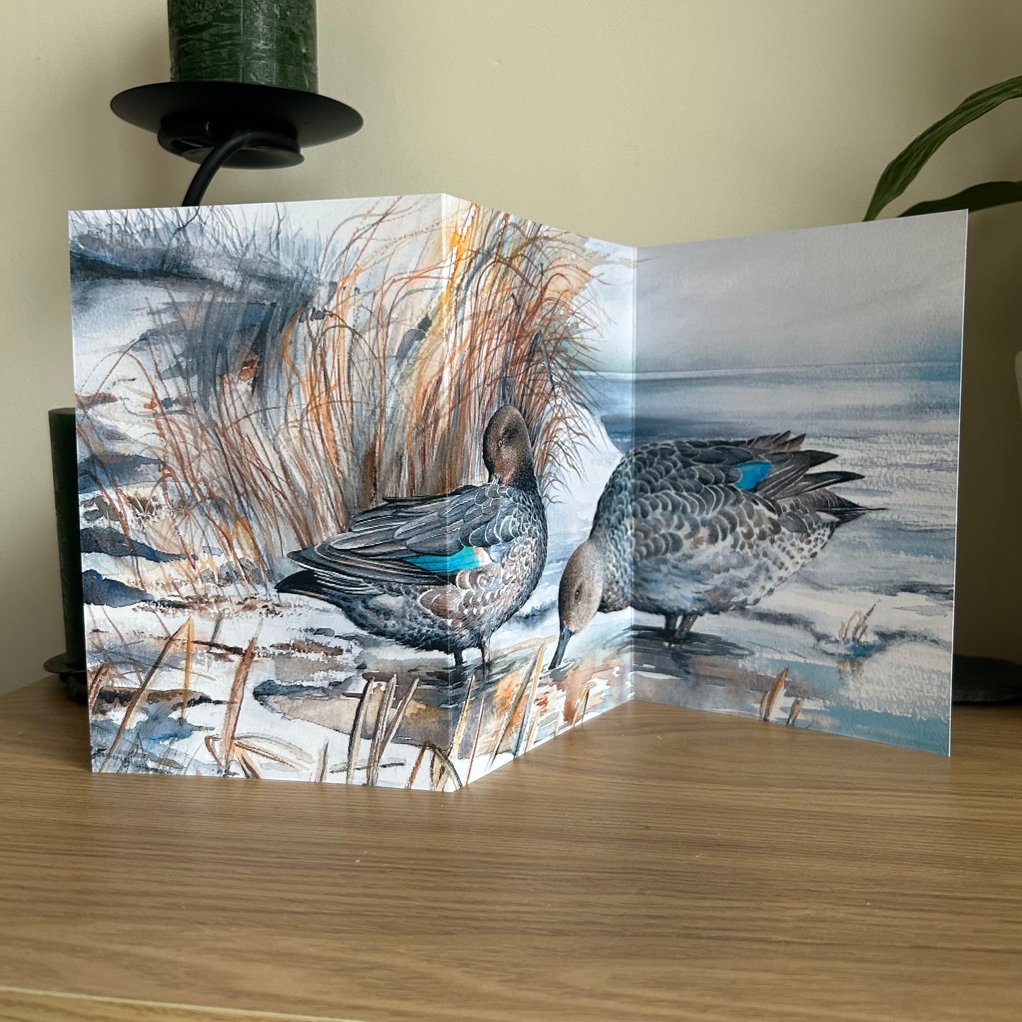 Trifold Greeting card with a painting of Teal ducks in a natural setting on a wooden surface.