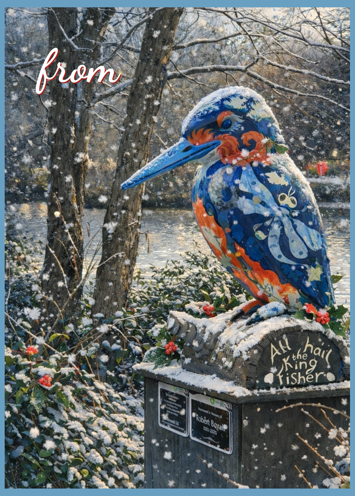 A greeting card design featuring a winter scene with a brightly painted blue kingfisher statue on a snowy stone pedestal beside a river, with falling snow and trees in the background. The word 'from' appears in cursive at the top left, and 'All hail the King Fisher' is written on the pedestal.