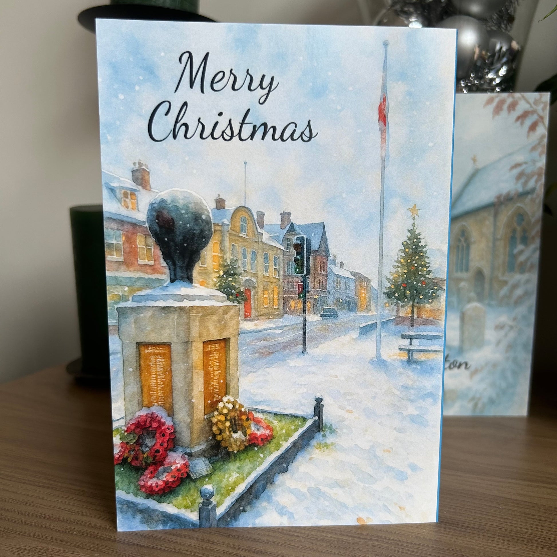 Christmas card with a snowy village scene and 'Merry Christmas' text.