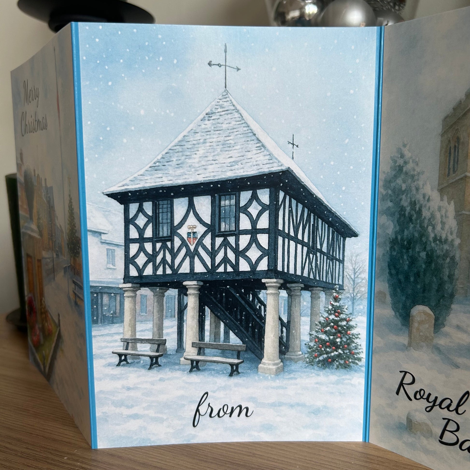 Christmas card with a snowy scene of a traditional building and trees