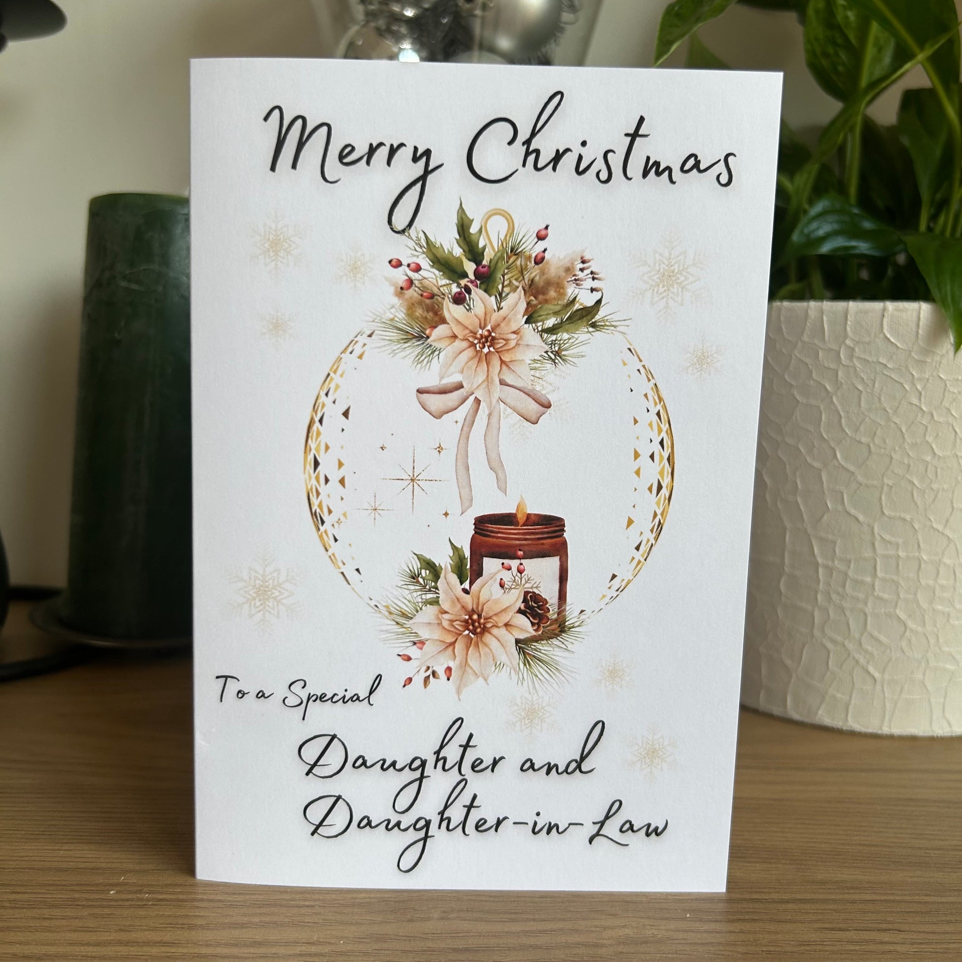 Christmas card with floral design and text on a wooden surface