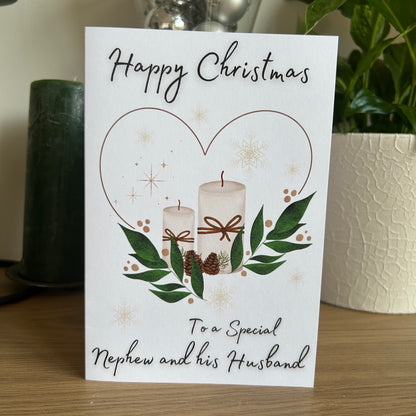 Christmas card with candles and greenery on a wooden surface