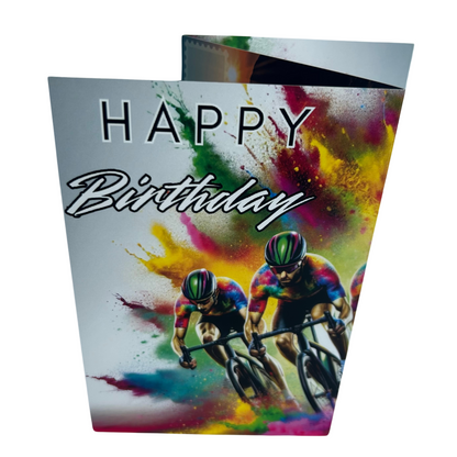 Trifold Male Cycling Birthday Card from the Push the Limit Range. Image shows the folded card depicting front with two cyclists in multicoloured cycling gear speeding aganst eash other and a background of colouful paint splatters emerging from behind them. The caption reads 'Happy Birthday'.
