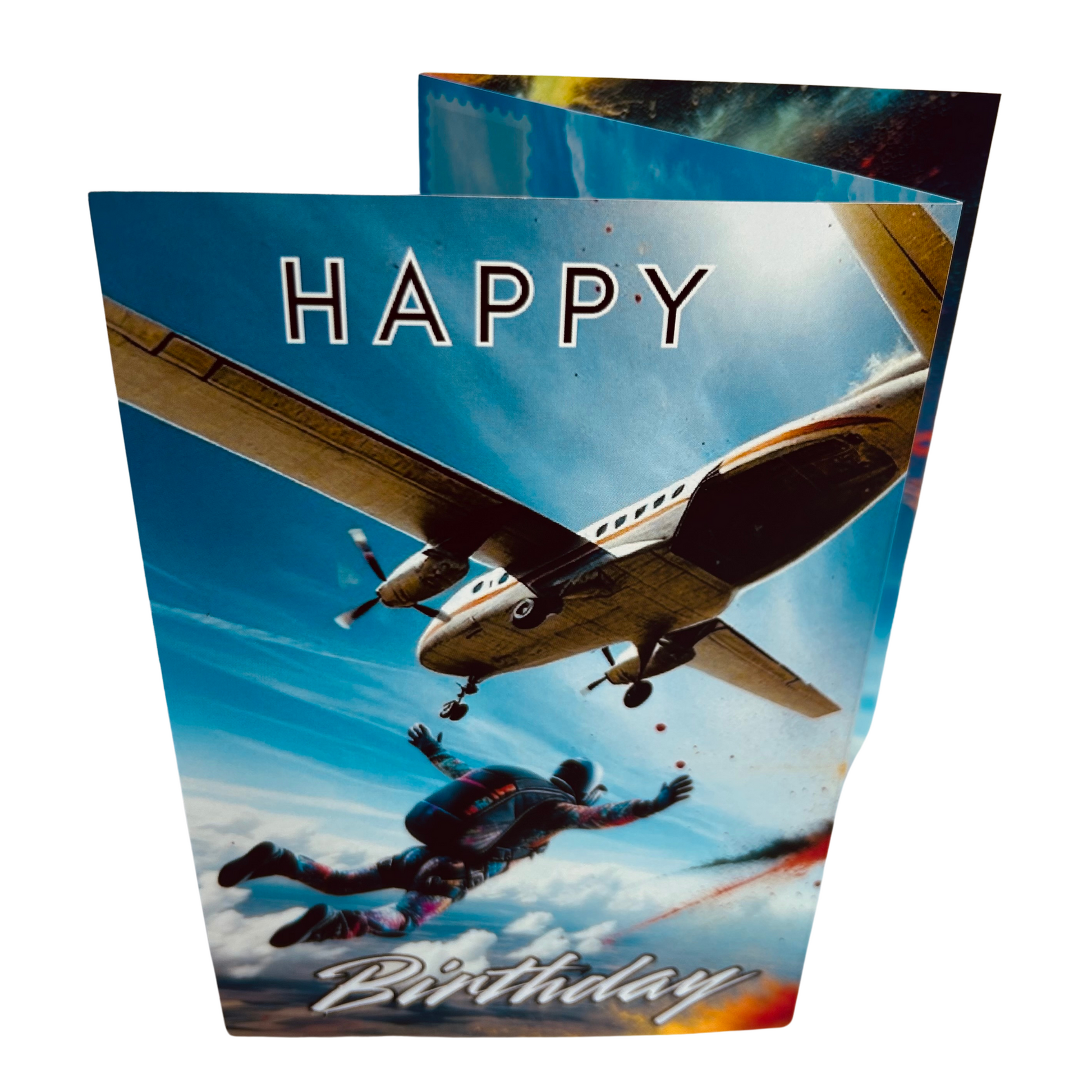 Trifold Sky Diving Birthday Card from the Push the Limit Range. Image shows the folded card depicting front with sky diver having just jumped from plane free falling with his arms out in a multicoloured suit and parachute pack and fields and clouds below, all on a background of clear blue sky. The caption reads 'Happy Birthday'.