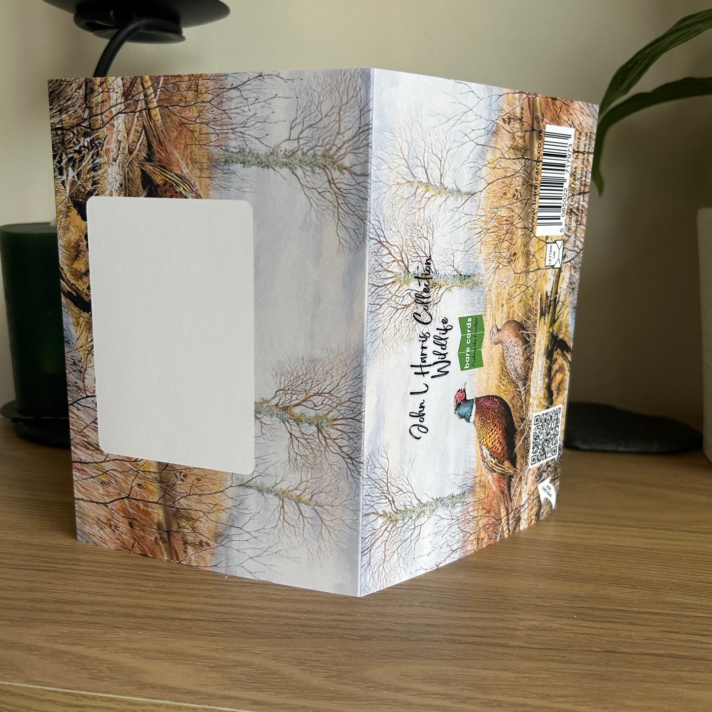 Envelope panels with nature-themed design for the John L Harris Wildlife greetings cards displayed on a wooden surface