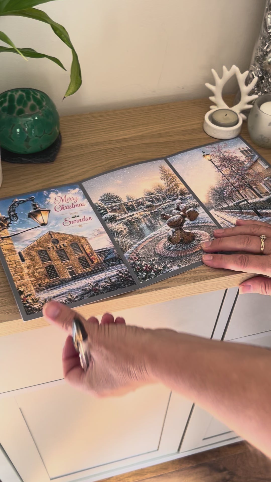 Demonstration of the Bare Cards Christmas Card for Swindon, showing how to write, fold seal, open and display the self-sealing card. This triptych card shows  festive images of Steam Museum, Queen's Park, Christchurch and The Railway Village